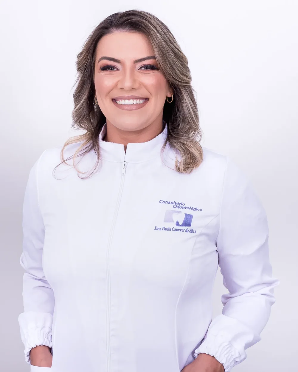 Dra. Paula Canever sorrindo, com jaleco branco